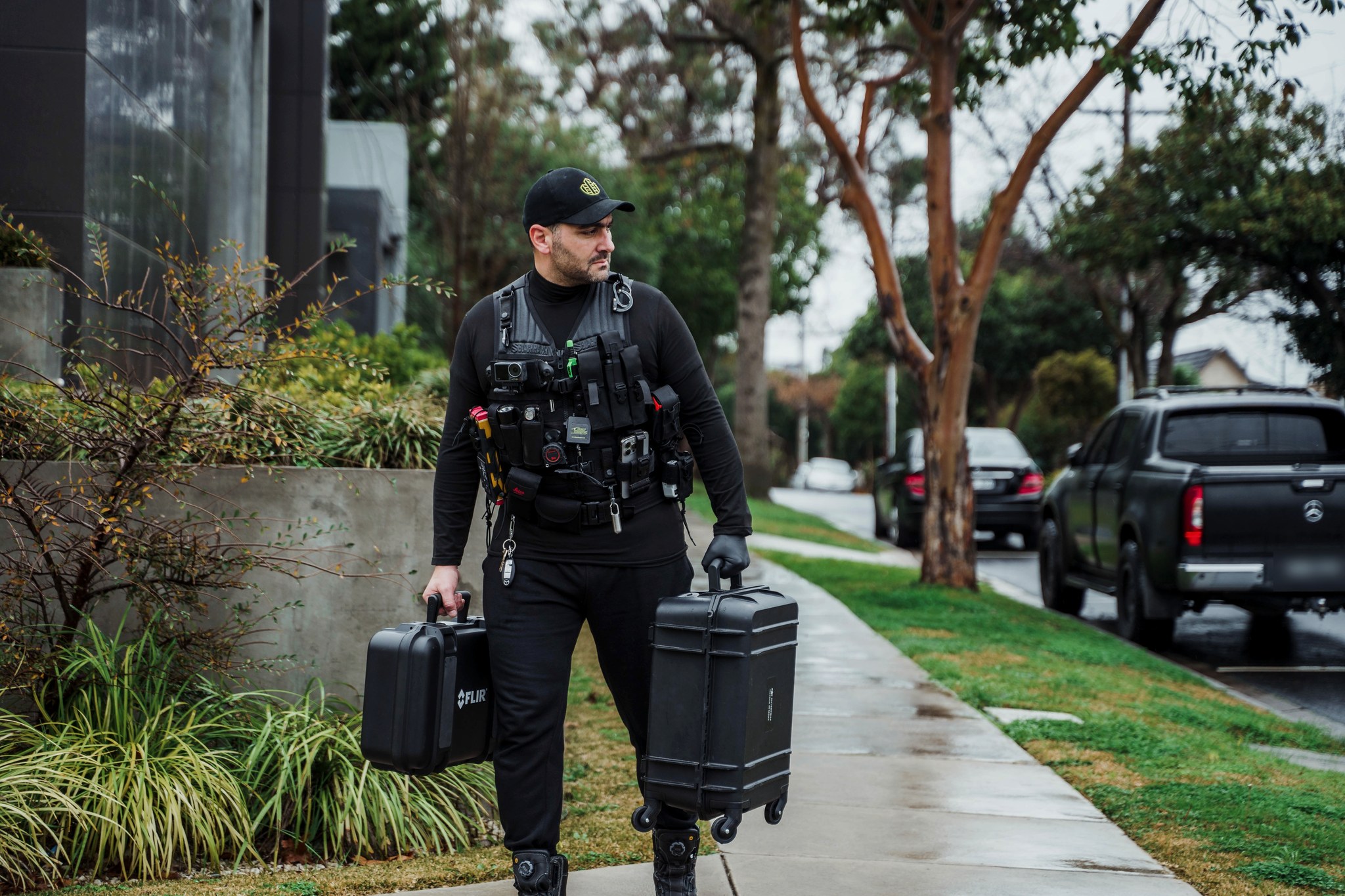 Zeher Khalil walking to an inspection carrying a FLIR thermal imaging case and a hard equipment case