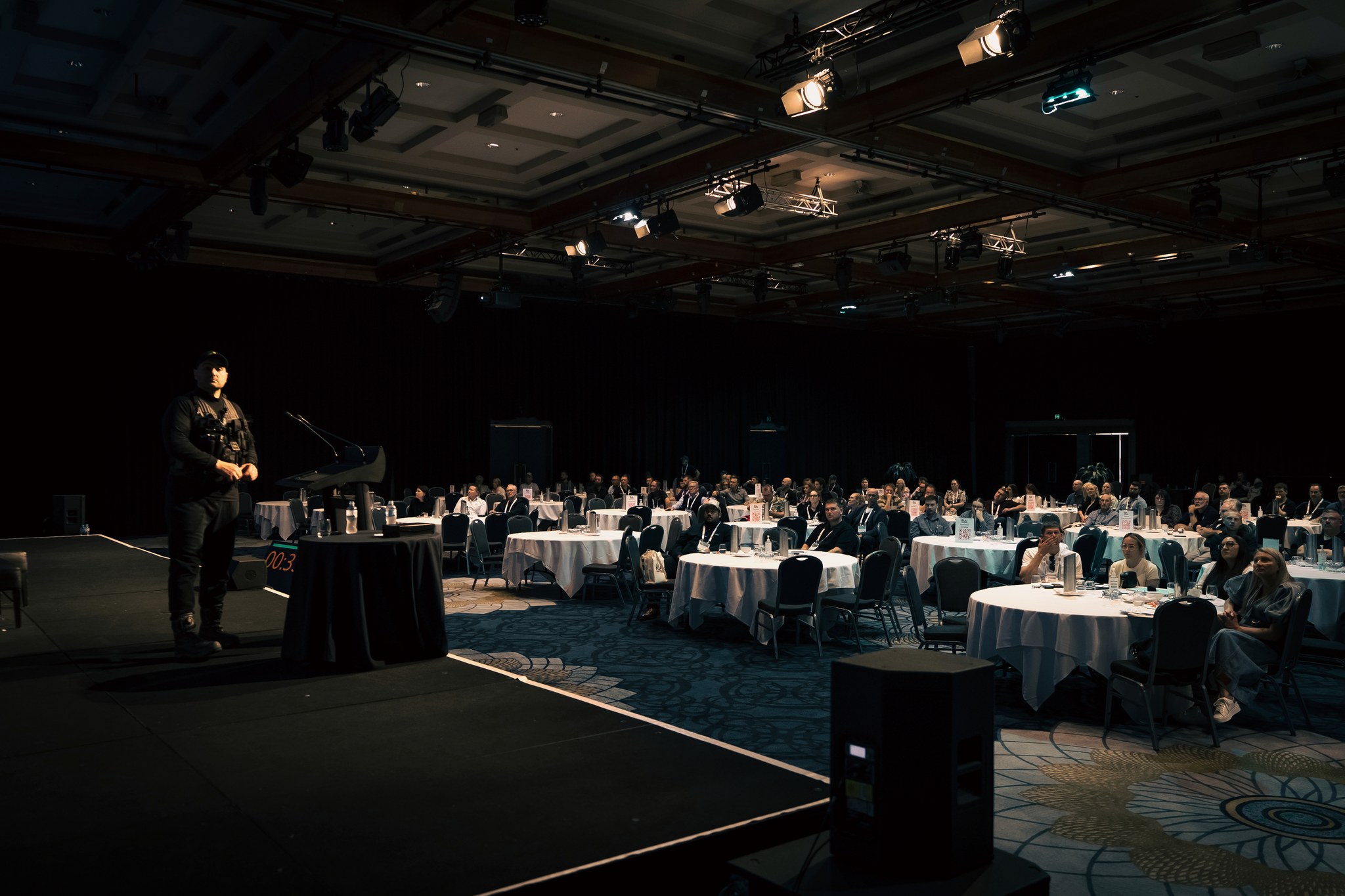 Zeher Khalil delivering a keynote address on stage to a full conference room