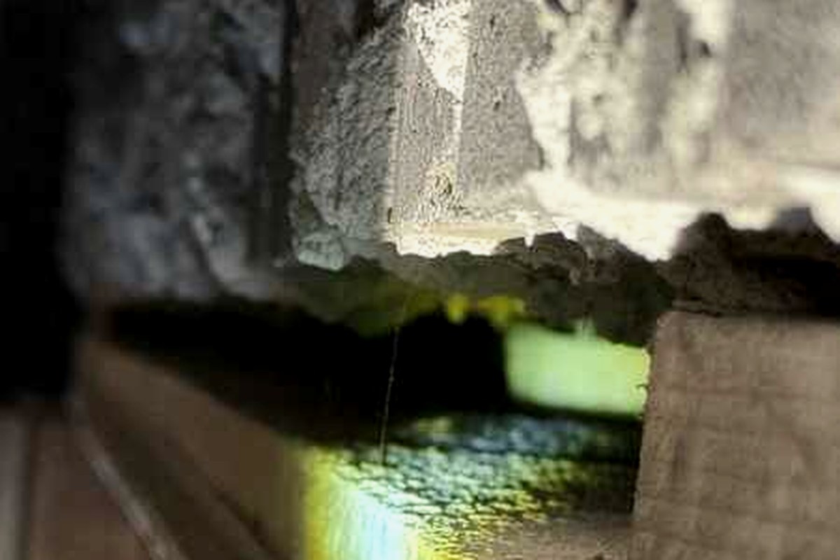 Underside of an external boundary wall showing an open void above the sill, with the wall cavity visible through the gap