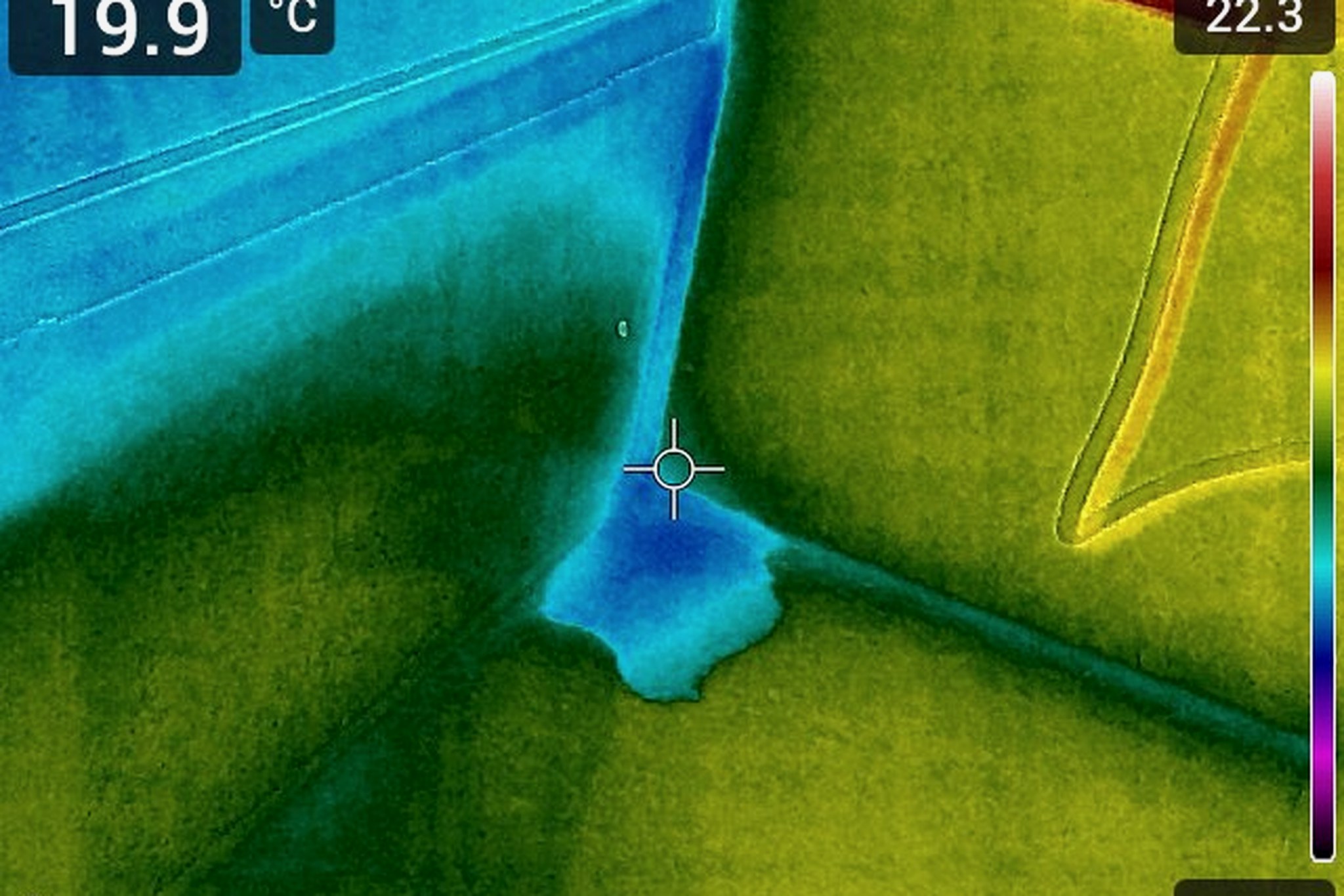 Thermal image showing a cold plume of moisture spreading down from a ceiling and wall junction, with surface temperatures of 19.9 and 22.3 degrees Celsius