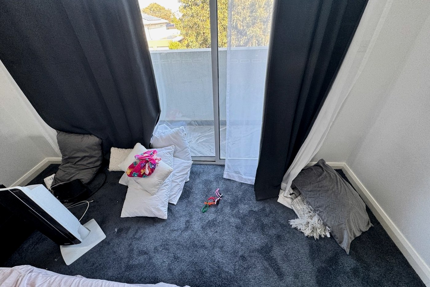 Pillows lined along the floor by a bedroom sliding door, as staged before the inspection