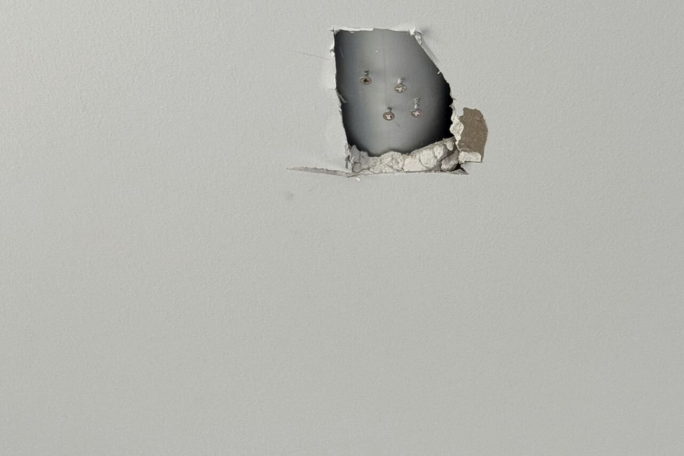 Damaged plasterboard left behind a fitting at completion