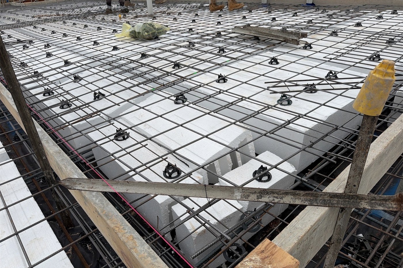 Reinforcing mesh and bar chairs over waffle pods on a residential slab, photographed before the concrete pour
