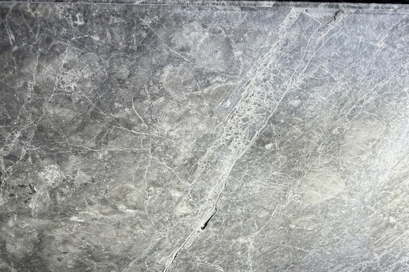 Patched repair in a stone benchtop found under angled light