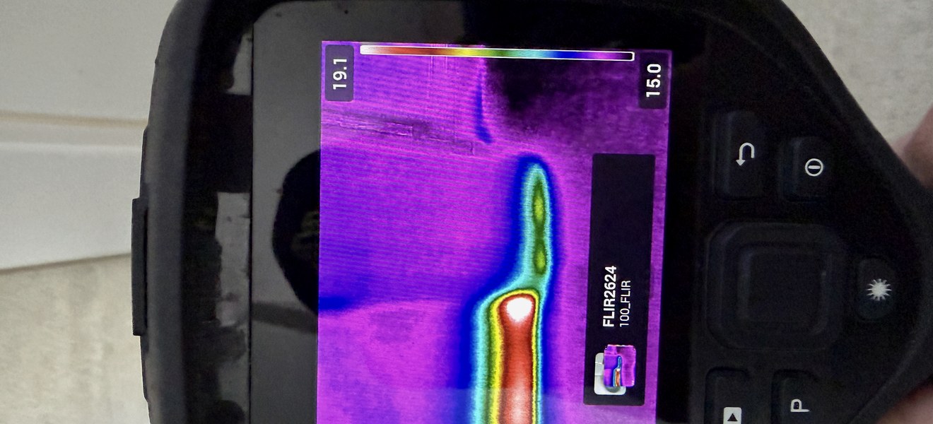 Thermal imaging camera revealing a moisture pattern behind a wall surface